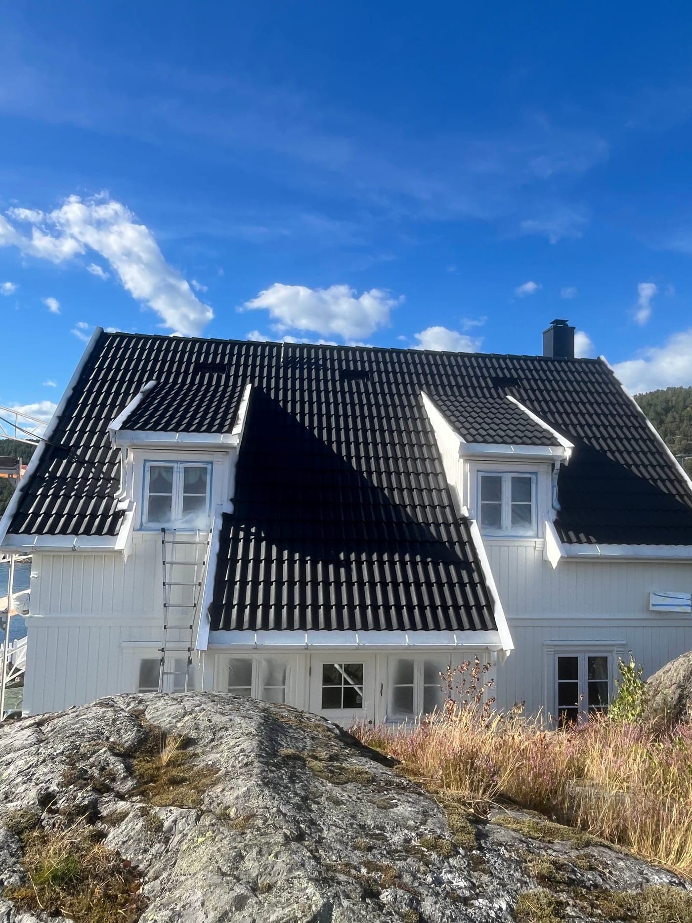 Ferdig fornyet tak på hvitt hus ved sjøen